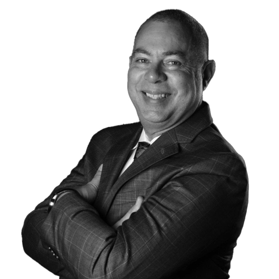 Dr. Miguel Casañas, 2x Practice Owner from New York, wearing a checkered suit and smiling confidently with arms crossed